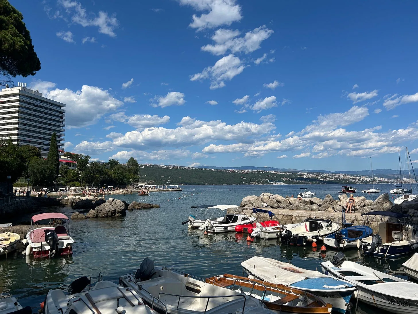 Boats moored in Opatija harbour on the Croatian coast, with wooded hills and the Adriatic behind