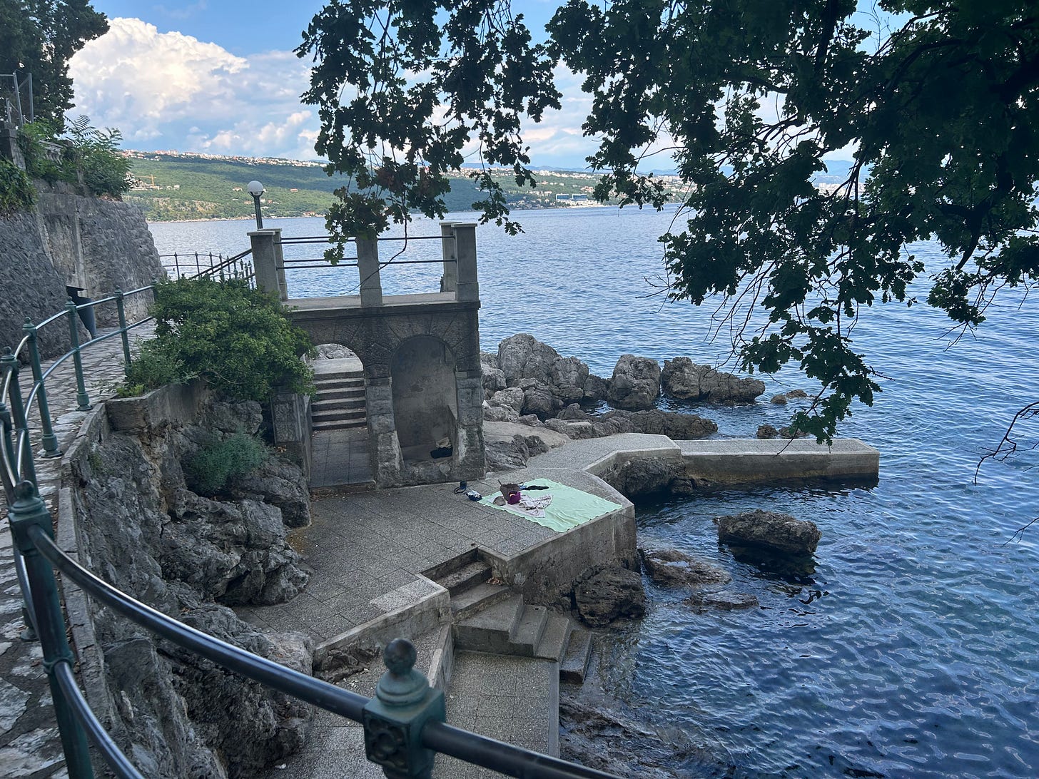 A stone bathing terrace and steps on the Opatija coastal path beside the Adriatic